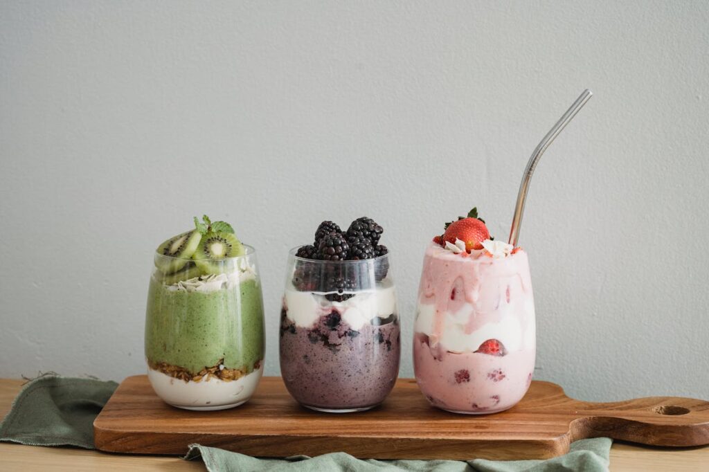 Three colorful plant-based smoothies to lose weight naturally with berries, kiwi, and coconut — healthy breakfast idea.